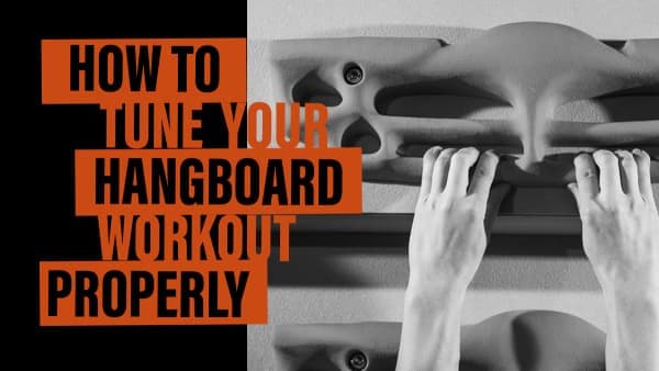Black-and-white view of two hands hanging from finger edges on a hangboard