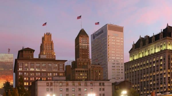 Downtown Newark office towers with American flags glowing under a pink and purple dusk sky
