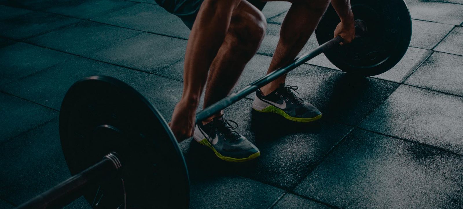 Member lifting a loaded barbell on the gym floor